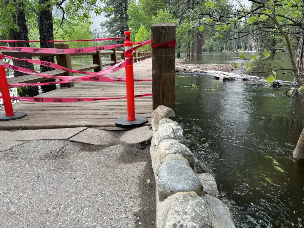 Floodwater almost covering a wooden walkway in Yosemite Valley